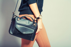 beautiful young woman posing with handbag and copy space